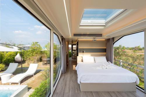 a bedroom with a bed and a balcony at Nx Space พลูวิลล่า in Nakhon Nayok
