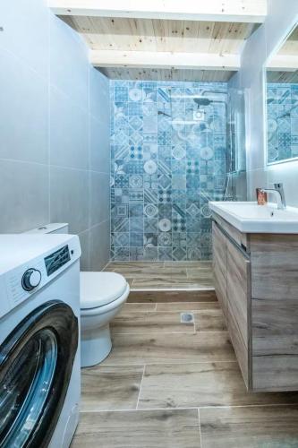 a bathroom with a toilet sink and a washing machine at Casa Daria in Topólia