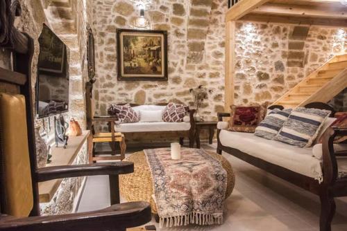 a living room filled with furniture and a stone wall at Casa Daria in Topólia