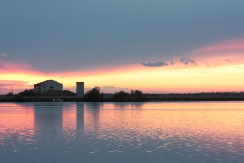 a sunset over a large body of water at Residenza le Saline in Comacchio