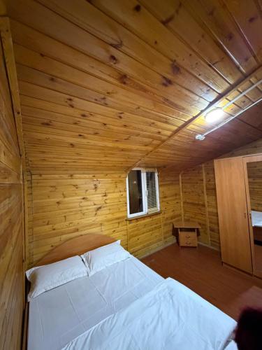 a bedroom with a bed in a wooden room at Rif Burabay in Borovoye