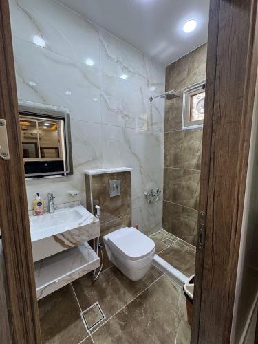 a bathroom with a toilet and a sink and a shower at شقق الخامسه الفاخرة Al Amer Luxury Apartments in Aqaba