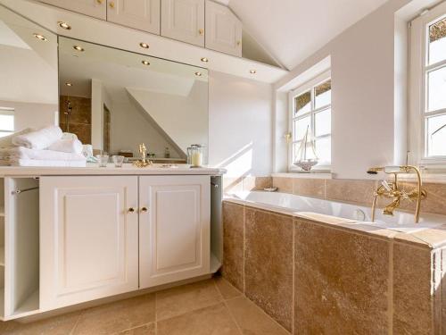 a bathroom with a tub and a sink and a mirror at Leuchtturmblick-Sued in Kampen