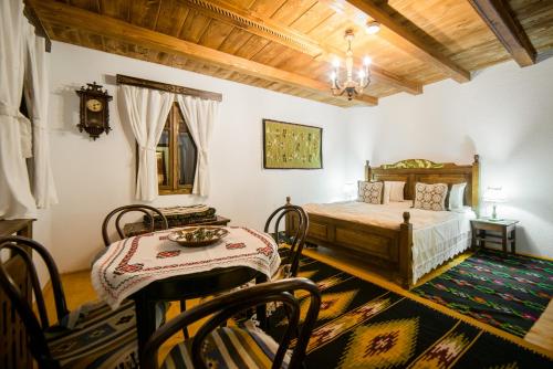 a bedroom with a bed and a table and chairs at Pension La Roata in Gura Humorului