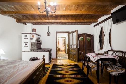 a bedroom with a bed and a table and chairs at Pension La Roata in Gura Humorului