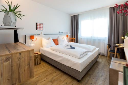 ein Hotelzimmer mit einem großen Bett und einem Tisch in der Unterkunft I´m Inn Wieselburg in Wieselburg