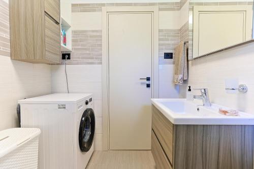 a bathroom with a washing machine and a sink at Family Villa Krizanci Istria in Žminj