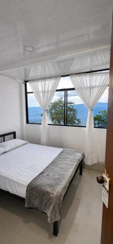 a bedroom with a bed and a large window at Hotel Casa Palma in La Mesa