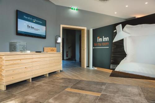 a bedroom with a bed and a tv on the wall at I´m Inn Wieselburg in Wieselburg
