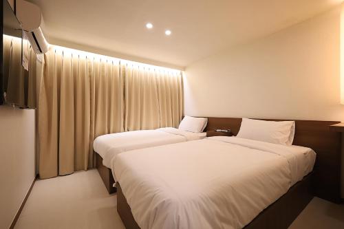 a hotel room with two beds and a window at Hotel Soonsu Mia in Seoul