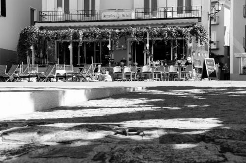 a group of people sitting in chairs in front of a building at Seven Boutique Hotel in Ascona