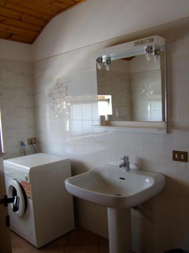 a white bathroom with a sink and a mirror at Agritur Fior di Melo in Nanno