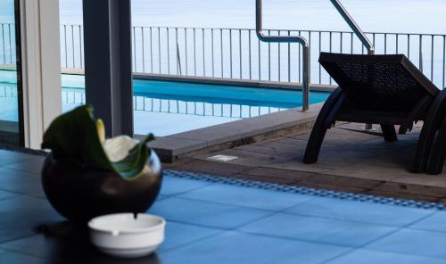 een vaas en een plant op een tafel naast een zwembad bij Hill Houses - Savoy Signature in Arco da Calheta