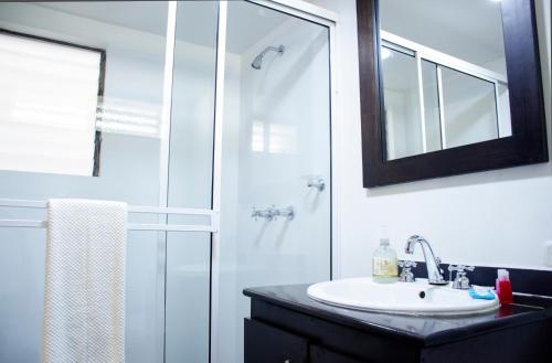 a bathroom with a sink and a shower with a mirror at Ayenda Apartamento Turistico Distrito 9 90 in Cali