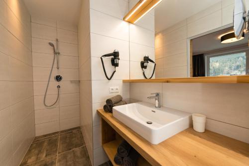 y baño con lavabo y ducha. en APART Forellenhof, en Flachau