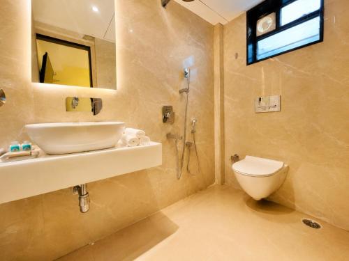 a bathroom with a sink and a toilet and a mirror at Hotel Eastern Dham Puri in Puri
