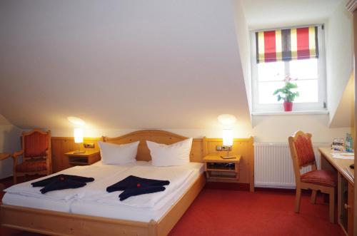a bedroom with a bed with two robes on it at Hotel Alttolkewitzer Hof in Dresden