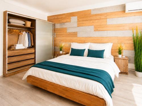a bedroom with a large bed with a wooden wall at Comfort 65 2-Bedroom Apartment with Balcony in Miskolc