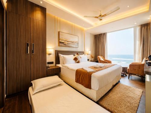 a hotel room with a bed and a large window at Hotel Eastern Dham Puri in Puri