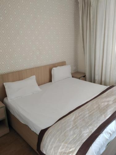 a bed with two white pillows sitting next to a window at The kanha Luxury Suites in Greater Noida