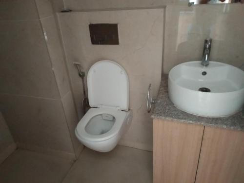a small bathroom with a toilet and a sink at The kanha Luxury Suites in Greater Noida