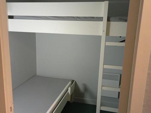 a small room with a bunk bed and a ladder at Camping des Cèpes in La Salvetat