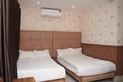 a room with two beds and a air conditioner at Hotel Nova in Itahari