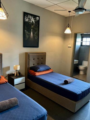a bedroom with two beds and a bathroom at BRICKS Cameron Hostel in Tanah Rata
