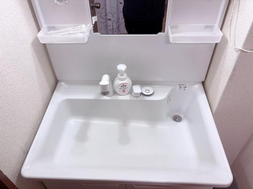 a white sink in a bathroom with a mirror at ZY House in Osaka