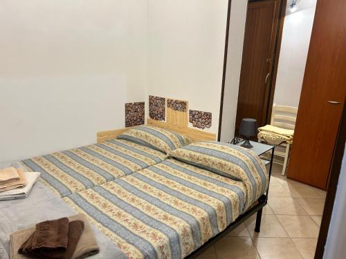 a bedroom with a large bed with a striped comforter at Alloggio Turistico Grottaferrata in Grottaferrata