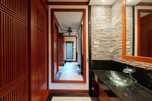 a bathroom with a sink and a hallway at The Baan Bua Elefant Villa in Rawai Beach