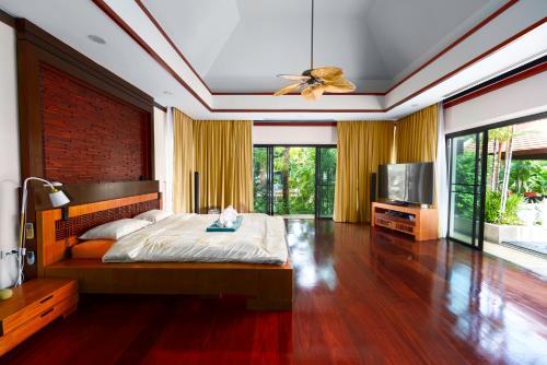 a bedroom with a bed and a ceiling fan at The Baan Bua Elefant Villa in Rawai Beach