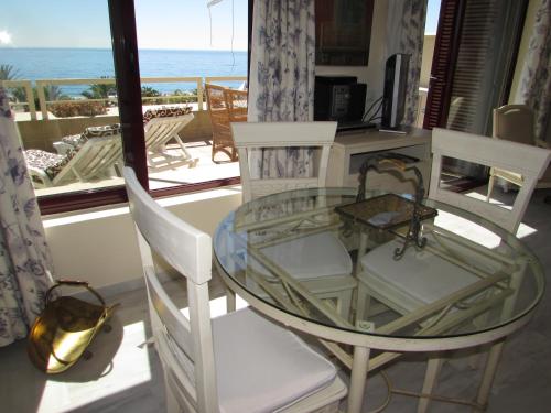 a glass table and chairs with a view of the ocean at Home4Holidays in Nerja