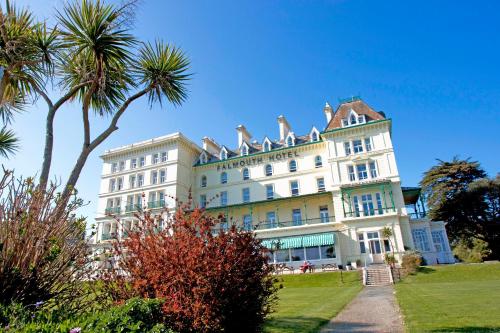 a large white building with palm trees in front of it at The Falmouth Hotel in Falmouth