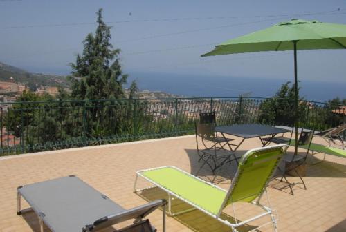 a patio with a table and chairs and an umbrella at B&B Villa zia Febronia in Patti