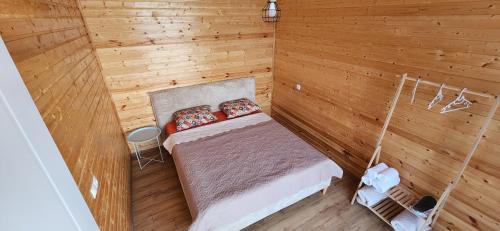a small bedroom with a bed in a wooden room at Bobokvati Eco Twins in Dagva