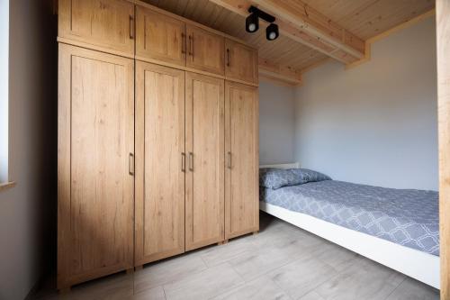 a bedroom with a bed and wooden cabinets at Agroturystyka Oliweczka 24 in Potok Wielki