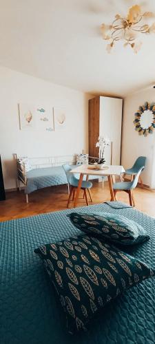 a bedroom with a table and a bed with a green blanket at Gina&Gian Guest House in Olbia