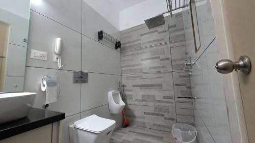 a bathroom with a shower and a toilet and a sink at Science House Lux Inn in Kadayirippu