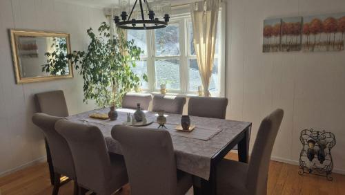 a dining room table with chairs and a large window at Anissa Shasta Hostel in Weed