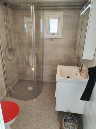 a bathroom with a shower and a sink and a toilet at Strandskatan 102 in Halmstad