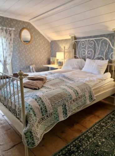 a bedroom with a bed with a quilt on it at Klevs gästgiveri 25 min från Ullared in Mårdaklev