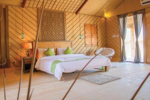 a bedroom with a bed in a room with wooden walls at SAMA Ras Al Jinz Ecolodge in Sur