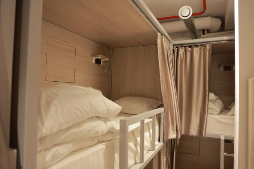 a bunk bed with white pillows in a room at PREMIUM DOO Hostel in Tashkent