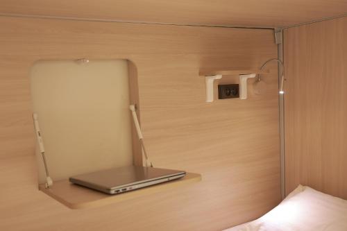 a laptop sitting on a shelf next to a wall at PREMIUM DOO Hostel in Tashkent