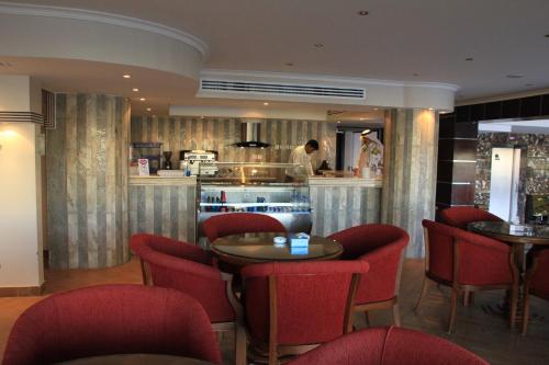 a restaurant with red chairs and a chef in the kitchen at APARTMENT near GULF DELMON in Dammam