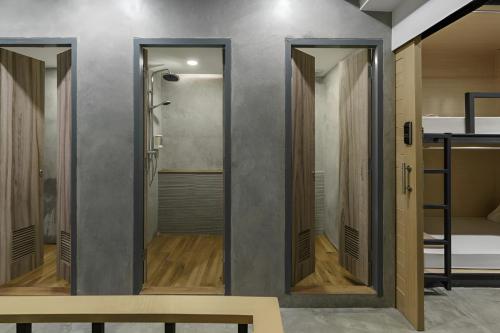 a walk in shower in a room with a bench at ORA Hostel Bangkok in Bangkok