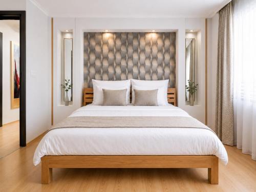 a bedroom with a large bed with white pillows at Comfort 66 Large Family City Home in Miskolc
