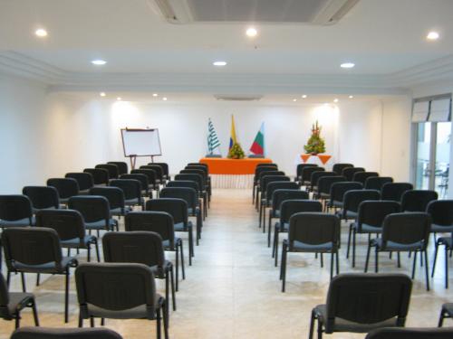 a row of chairs in a room with christmas trees at Hotel Sol Dorado in Villavicencio