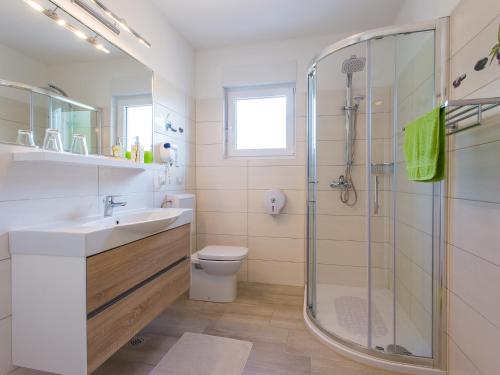 een badkamer met een douche, een wastafel en een toilet bij Villa Birikina with Pool in Poreč